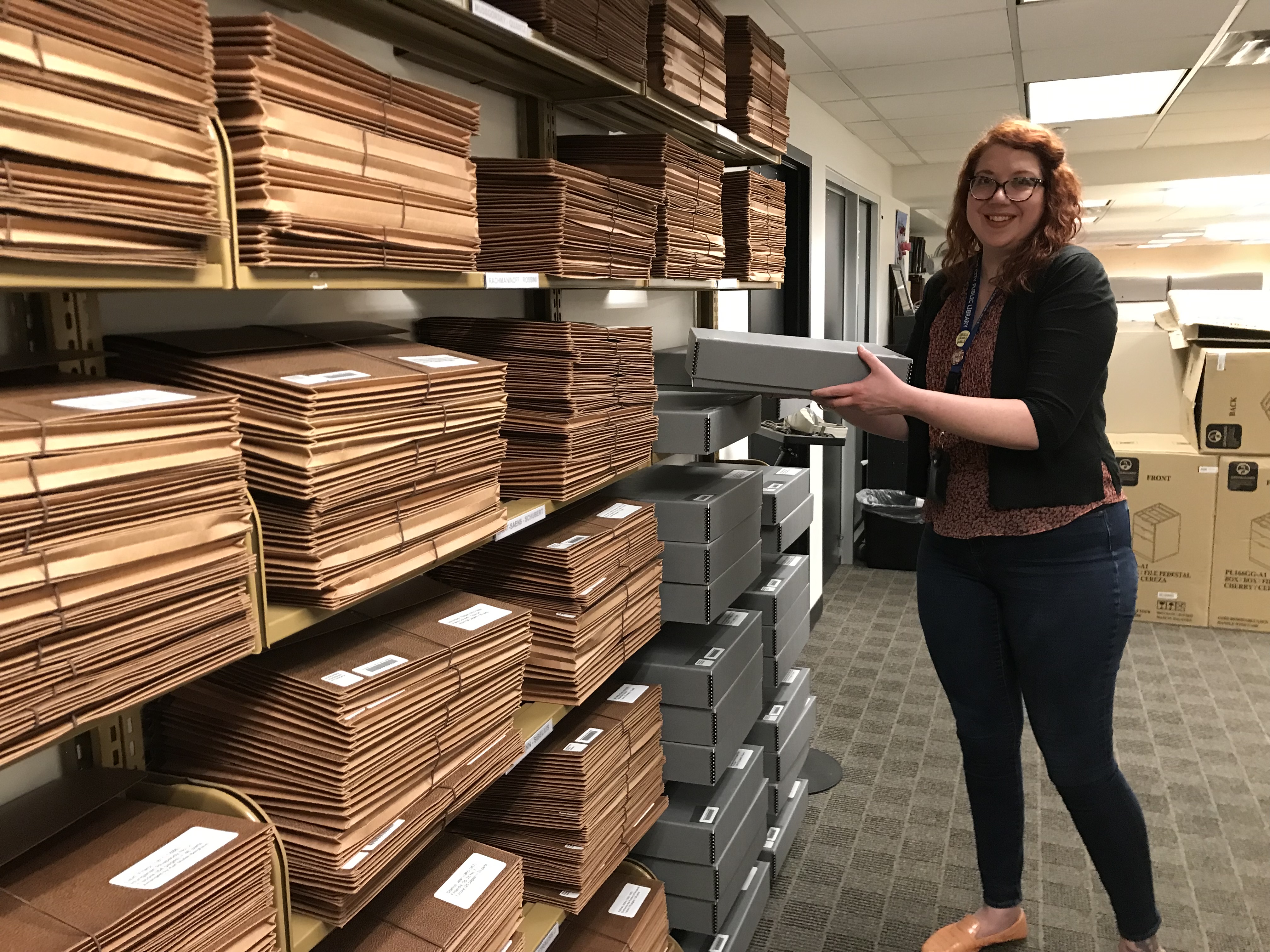 Library staff stands next to orchestral stacks