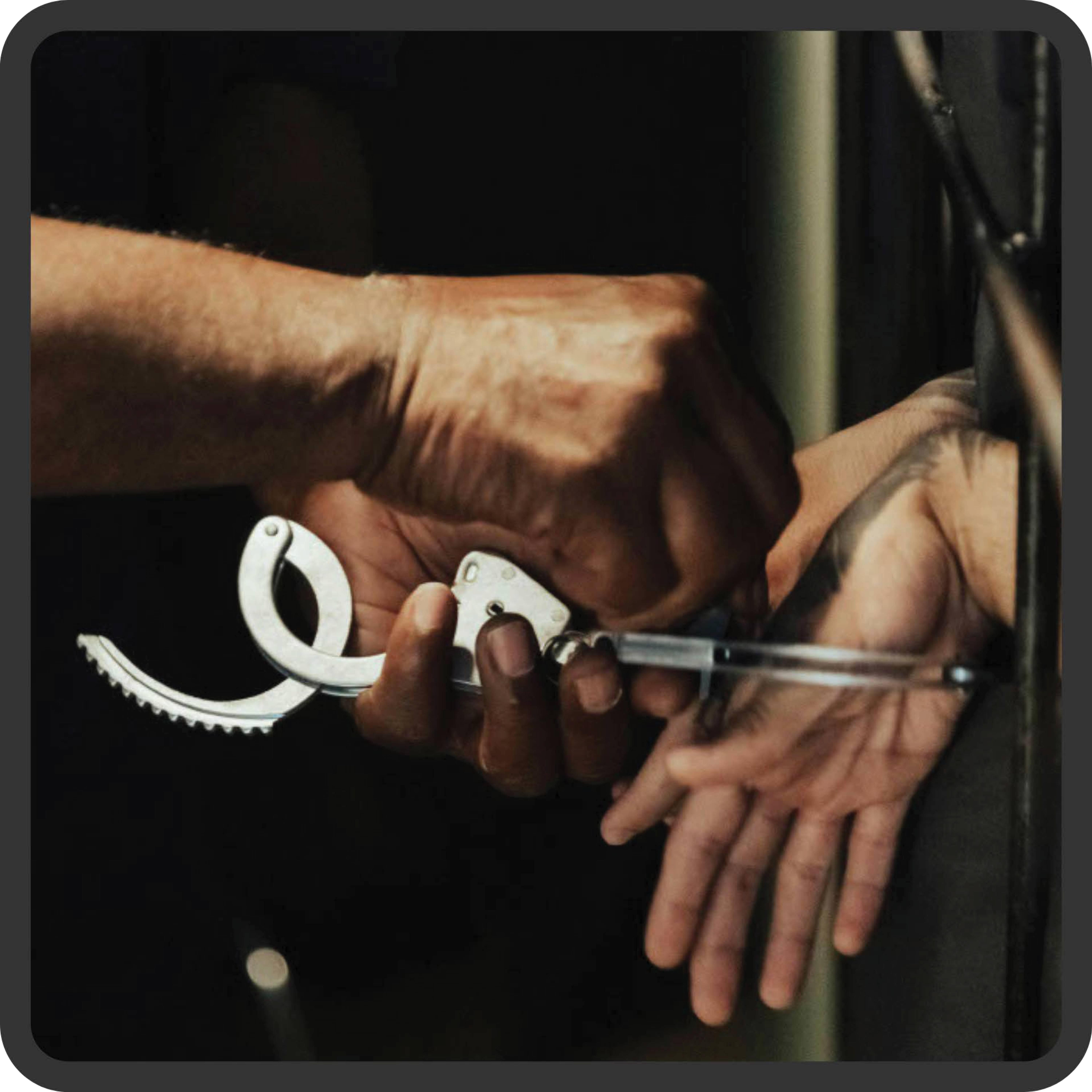 hands being uncuffed through prison bars