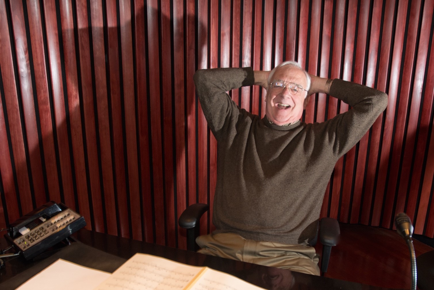 smiling man in recording studio leaning back in chair