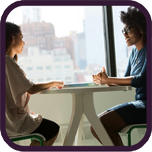 two people talking at table near window