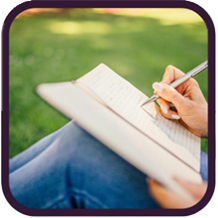 person sitting outside writing in journal