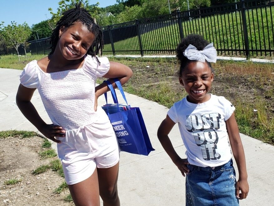 Two girls pose at MLK Park, one with a bag.