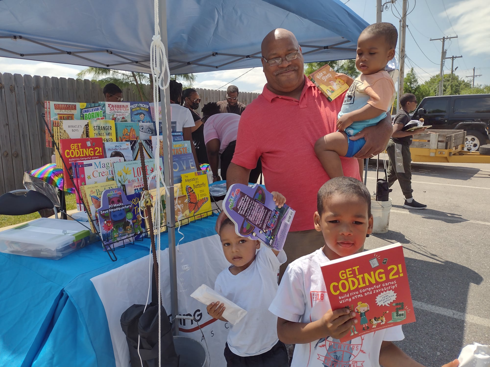 family picking out books at park