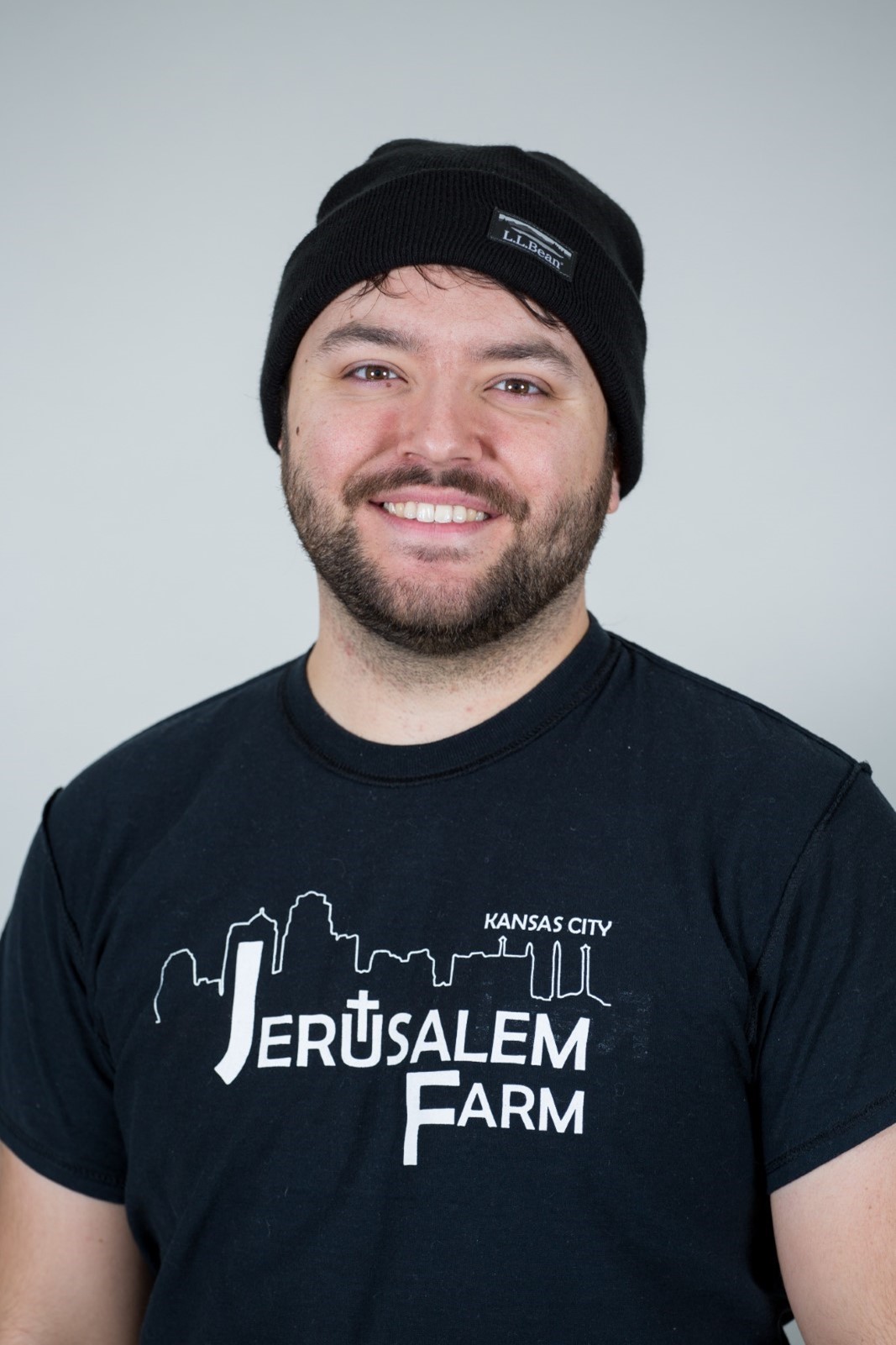 Man wearing a stocking cap and black t-shirt