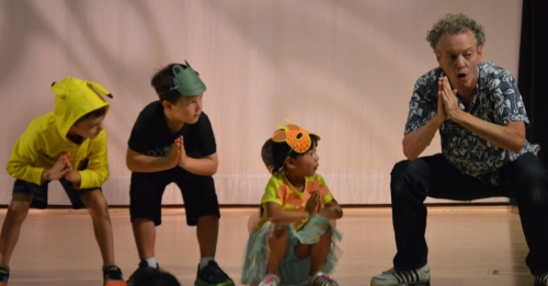 Kids in costumes and a teacher during a theater class