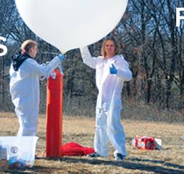 two people fill giant white balloon