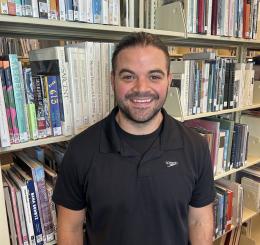 smiling person in front of books