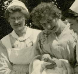 Three nurses holding an infant