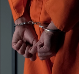 prisoner with hands cuffed behind back