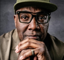 headshot of man with glasses and hat