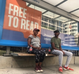 two people sit at streetcar stop