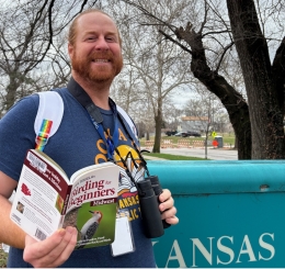 Ruiz Branch Manager Jimmy Thomas models a birdwatching kit near the branch sign.