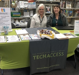 two women behind table smiling