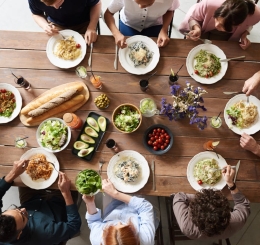 A group of people sit at a table eating a meal.