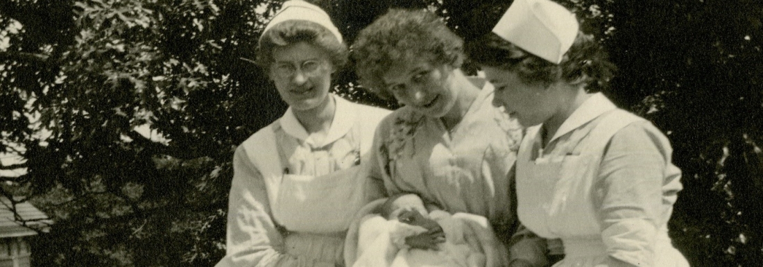 Three nurses holding an infant