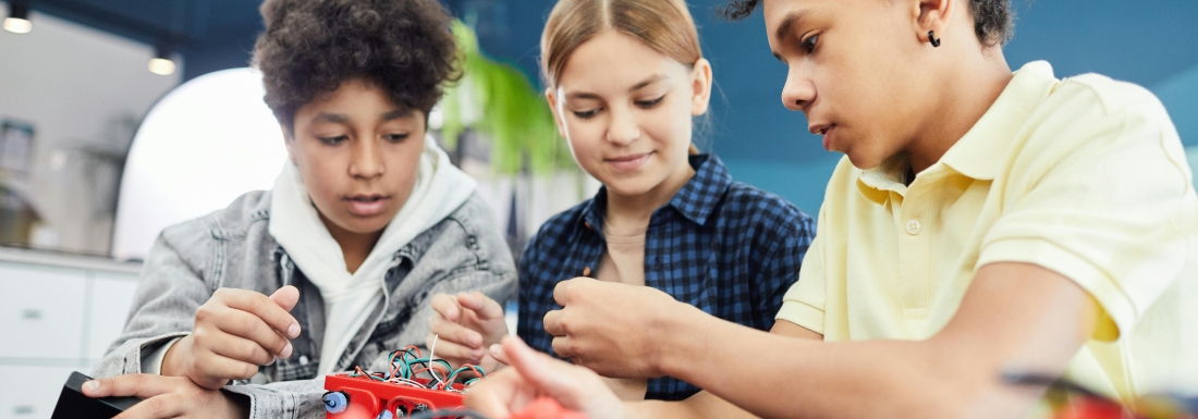 3 teens working together on an electronic project