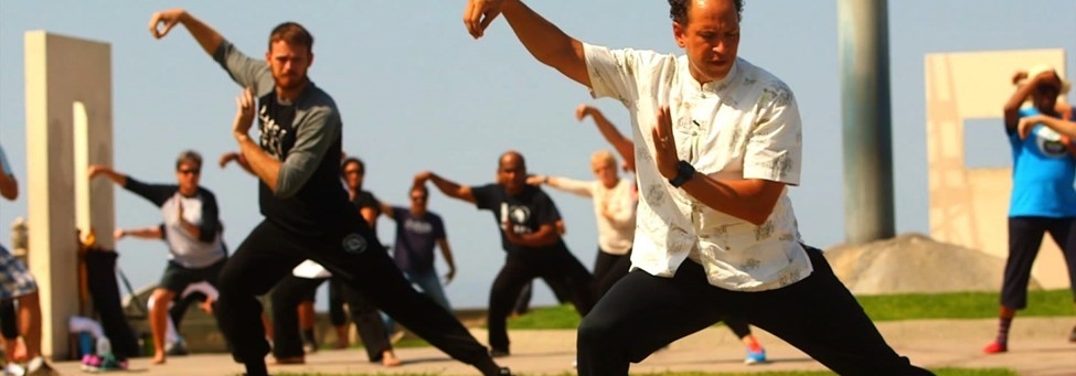 adults doing tai chi outdoors