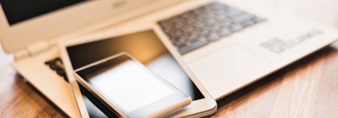 laptop, tablet, and phone stacked on table