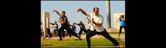 adults doing tai chi outdoors