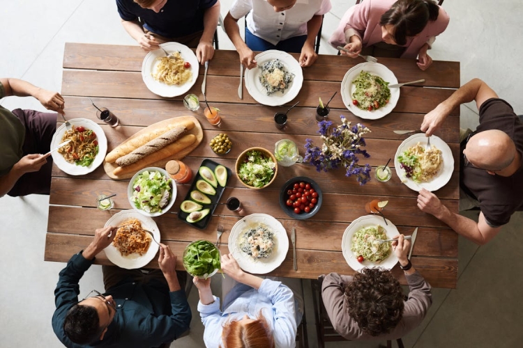 A group of people sit at a table eating a meal.