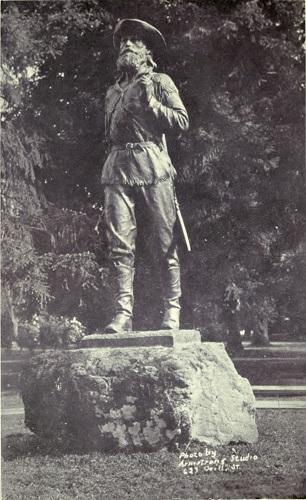 Photograph of a statue of a man with explorer's clothes wearing a long beard