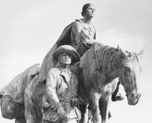 Profile image of a  statue of woman on horseback and one man visible leading the horse