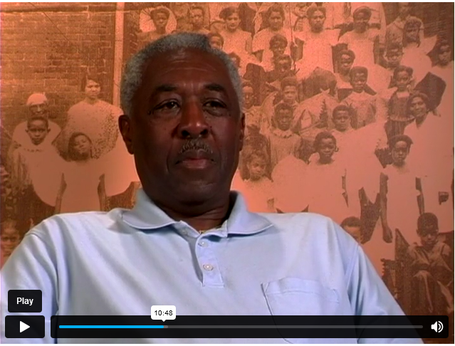 An African American man with a black and white photo background