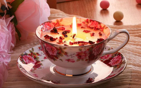 candle in teacup on plate