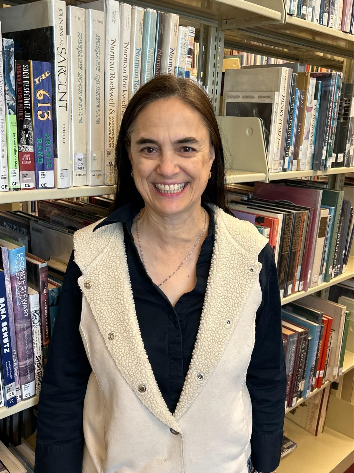 Smiling woman in front of a large bookshelf