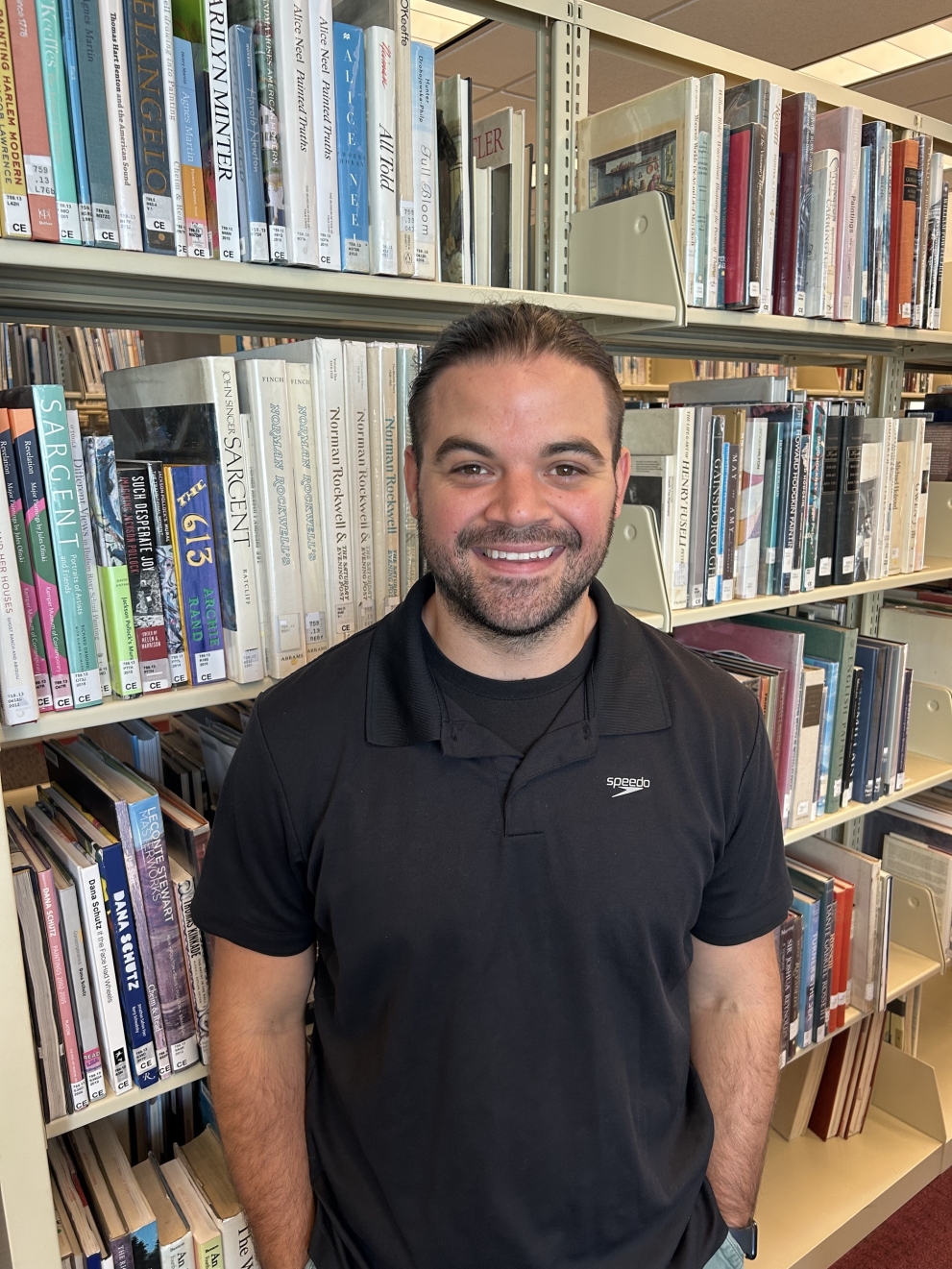 smiling person in front of books