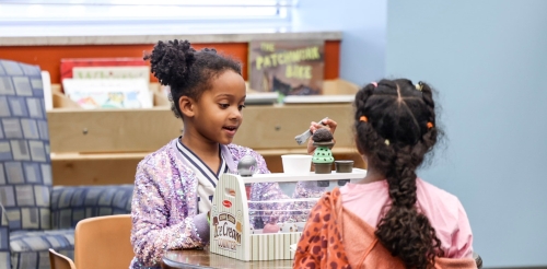 two girls playing at a table