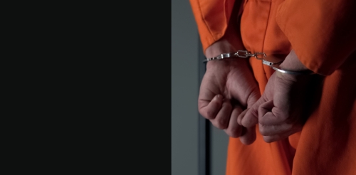 prisoner with hands cuffed behind back