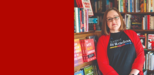 woman stands in front of books