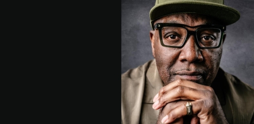 headshot of man with glasses and hat