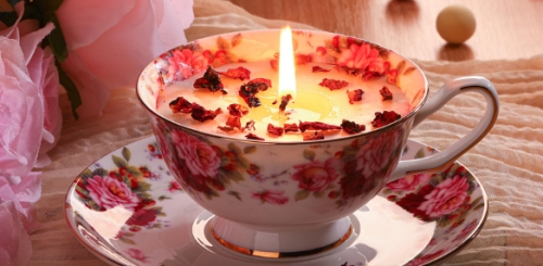 candle in teacup on plate