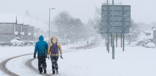 Two people walking on a snowy day