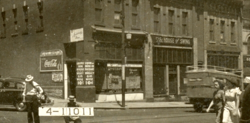 Two tax assessors in the street in front of a commercial building  and two women walking nearby