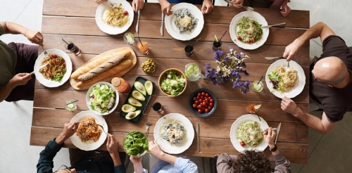 A group of people sit at a table eating a meal.